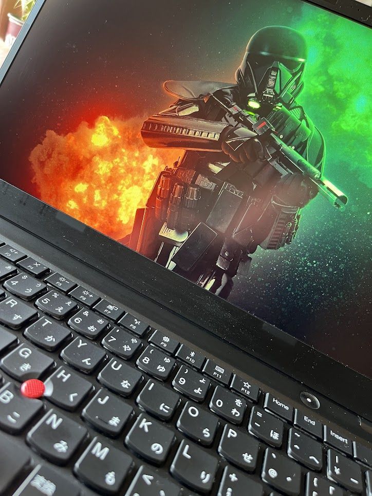 A Thinkpad X1 Carbon with clean desktop displaying wallpaper of a Star Wars character with explosions of colour behind.
