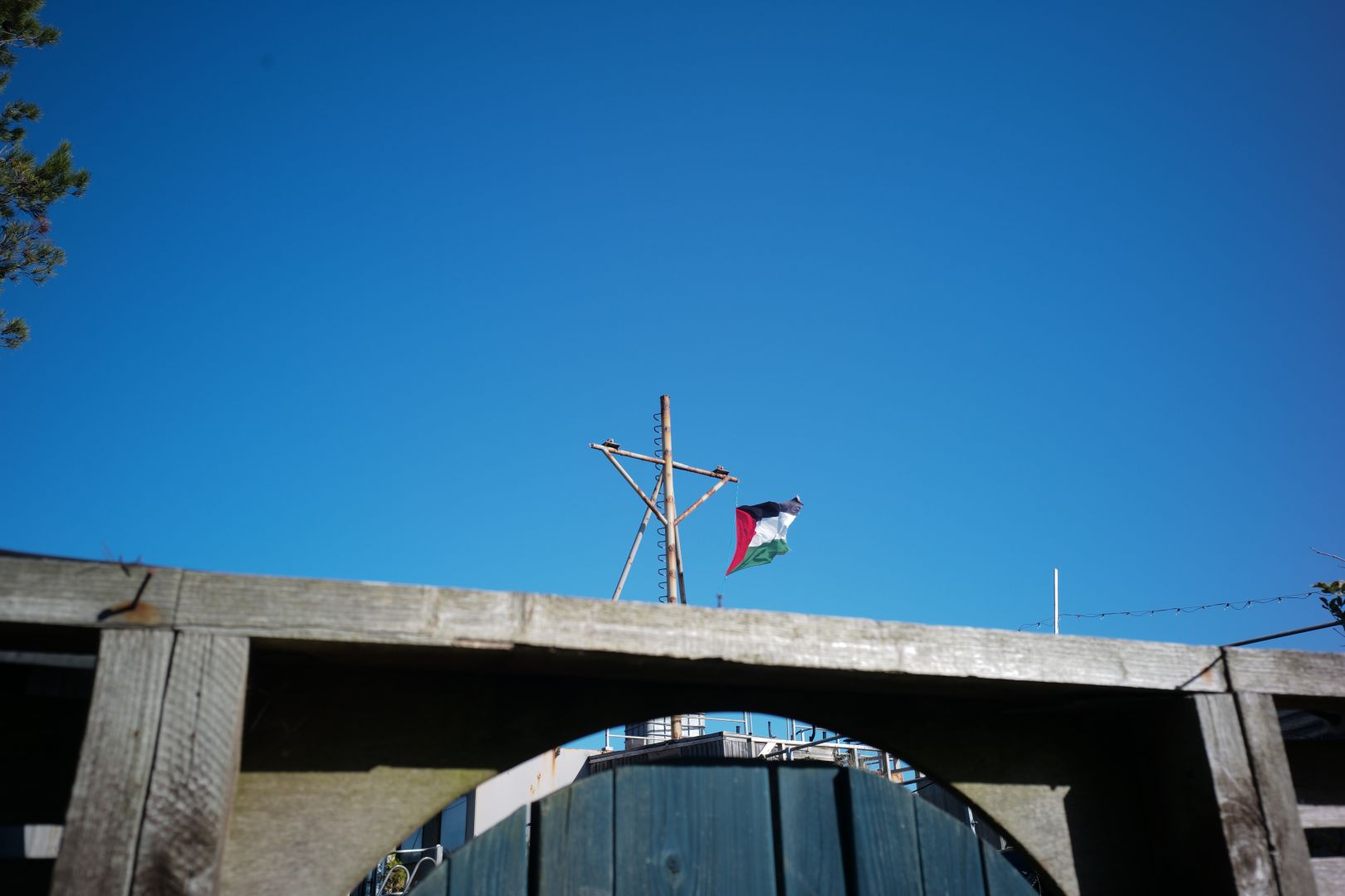 A Palestine flag peeks over the gate of a boathouse